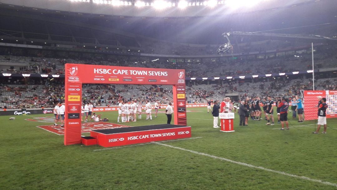 Packed stadium at a Cape Town Sevens rugby match with branded perimeter boards