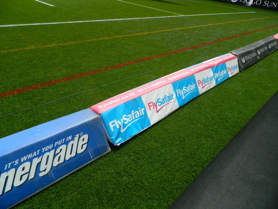 Pitch-side advertising boards running the length of a rugby field